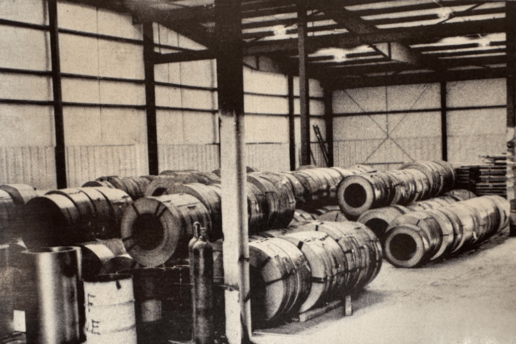Black and white photo showing steel coils stacked inside Chief Buildings’ expanded manufacturing plant in 1969.