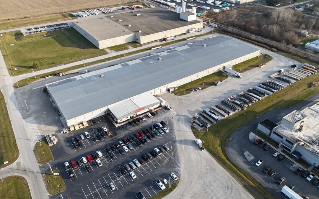 Aerial view of the Chief's facility in Rensselaer, Indiana, showing a large warehouse, semi-truck lot, office entrance, and surrounding farmland.