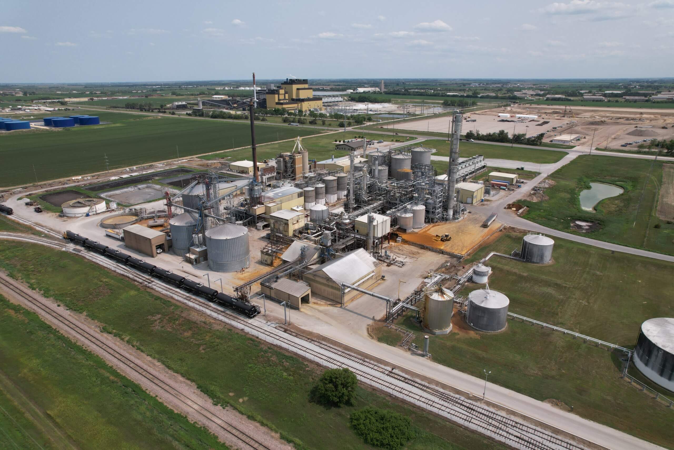 Aerial view of the Chief Ethanol plant in Hastings, Nebraska, featuring an extensive network of tanks, distillation columns, railcars, and processing infrastructure surrounded by farmland.