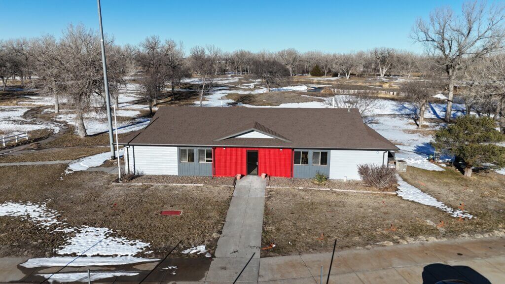 Aerial view of Chief Construction’s North Platte, NE office—a single-story building with red double doors, surrounded by winter landscape and snow patches.