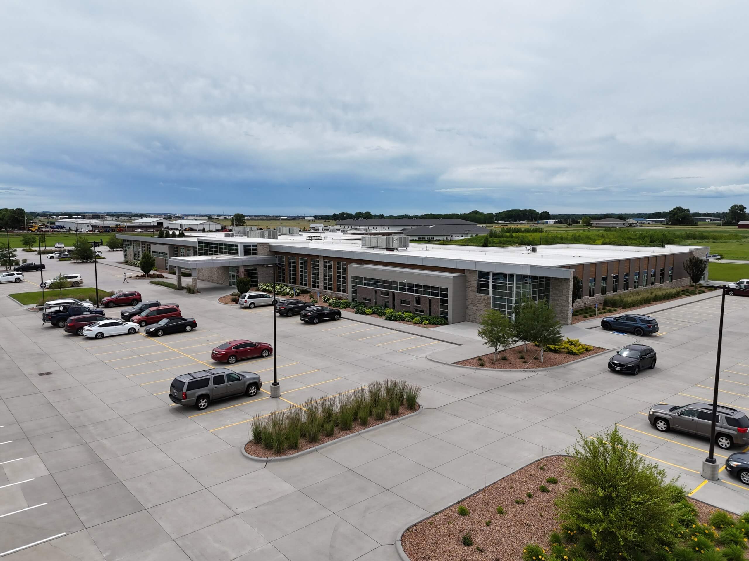 Aerial view of the modern Fountain Point medical office building in Norfolk, Nebraska, with landscaped surroundings and a full parking lot, built by Chief Construction.