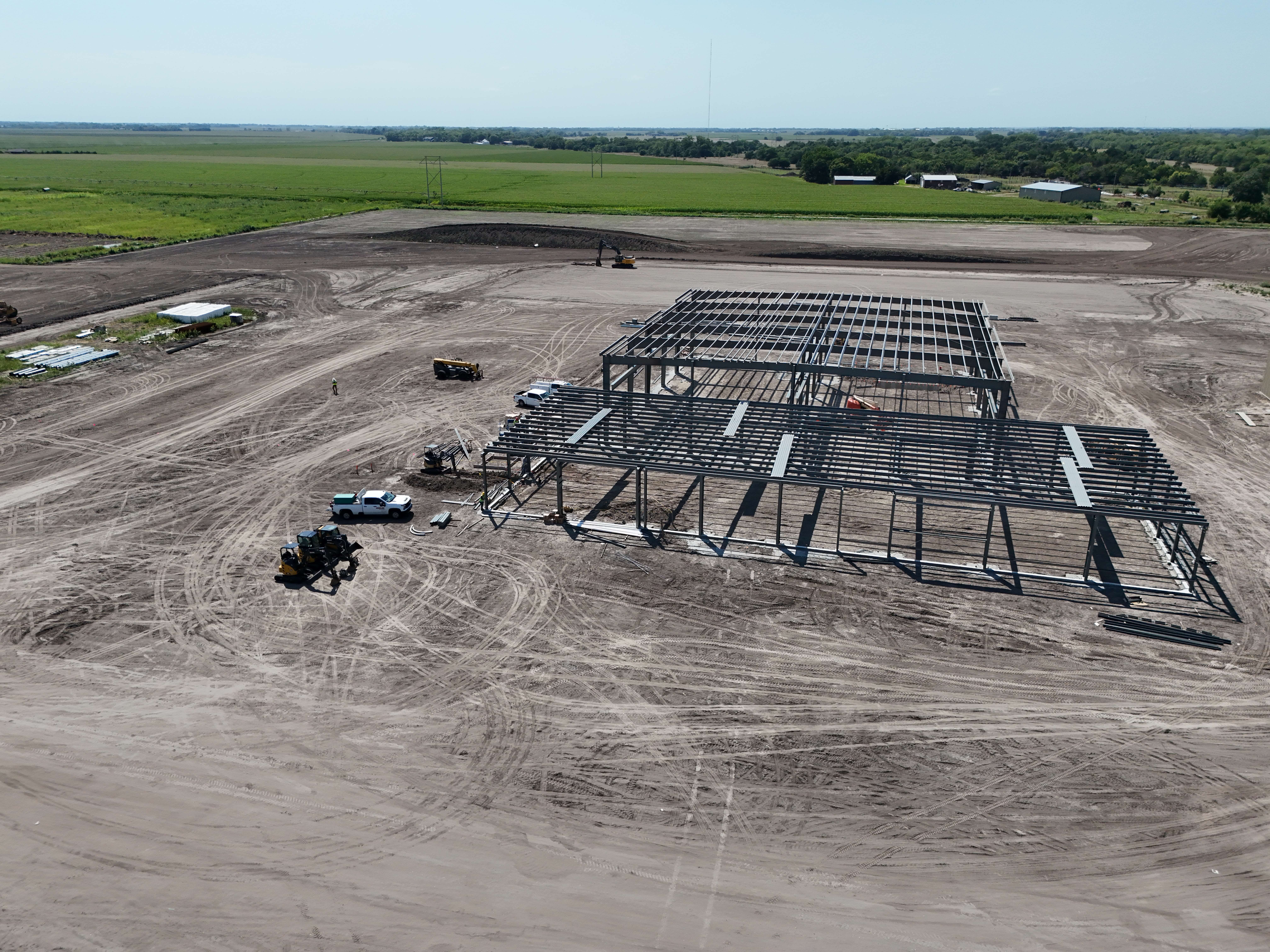 Aerial view of a steel-framed metal building under construction on a rural job site, manufactured by Chief Buildings and erected by Chief Construction.